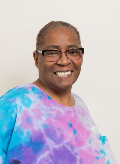Portrait Of A Smiling Team Member In A Colorful Tie-Dye Shirt