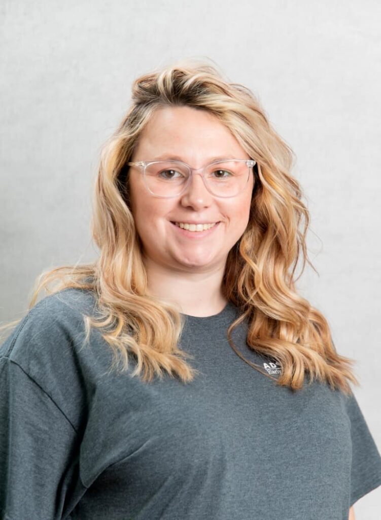 Portrait Of A Smiling Team Member In A Gray Shirt