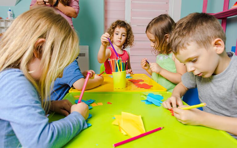 Children Creating Paper Crafts Together At A Classroom Table