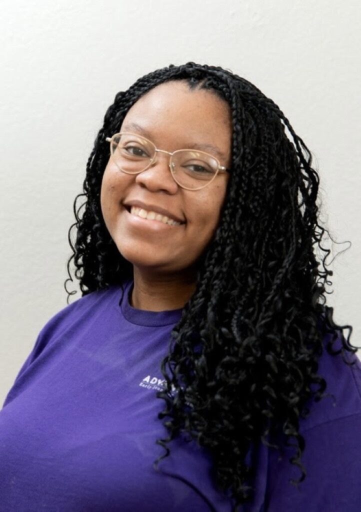Portrait Of A Smiling Team Member In A Purple Shirt