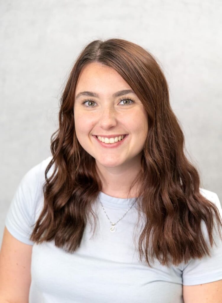 Portrait Of A Smiling Team Member In A White Shirt