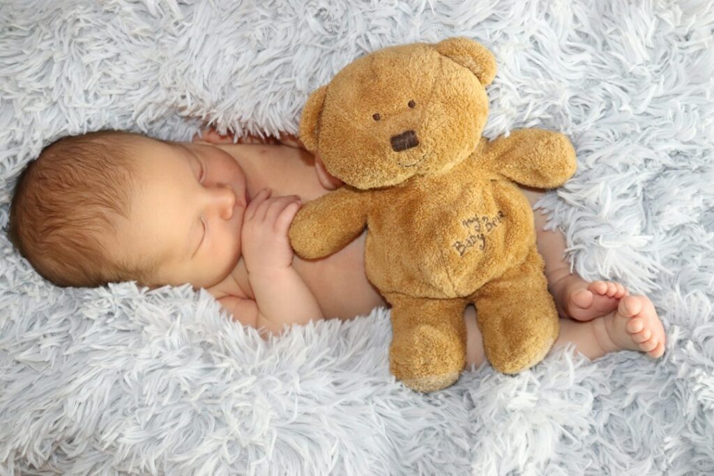 Sleeping Baby Resting Beside A Soft Teddy Bear